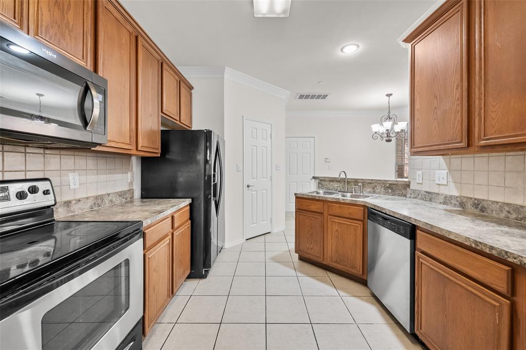 8524 Heather Ridge Drive Plano, TX 75024 - Photo 11 of 27 a kitchen with stainless steel appliances granite countertop a stove a sink and a microwave