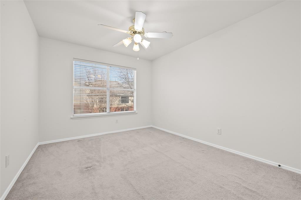8524 Heather Ridge Drive Plano, TX 75024 - Photo 18 of 27 an empty room with a chandelier fan and windows