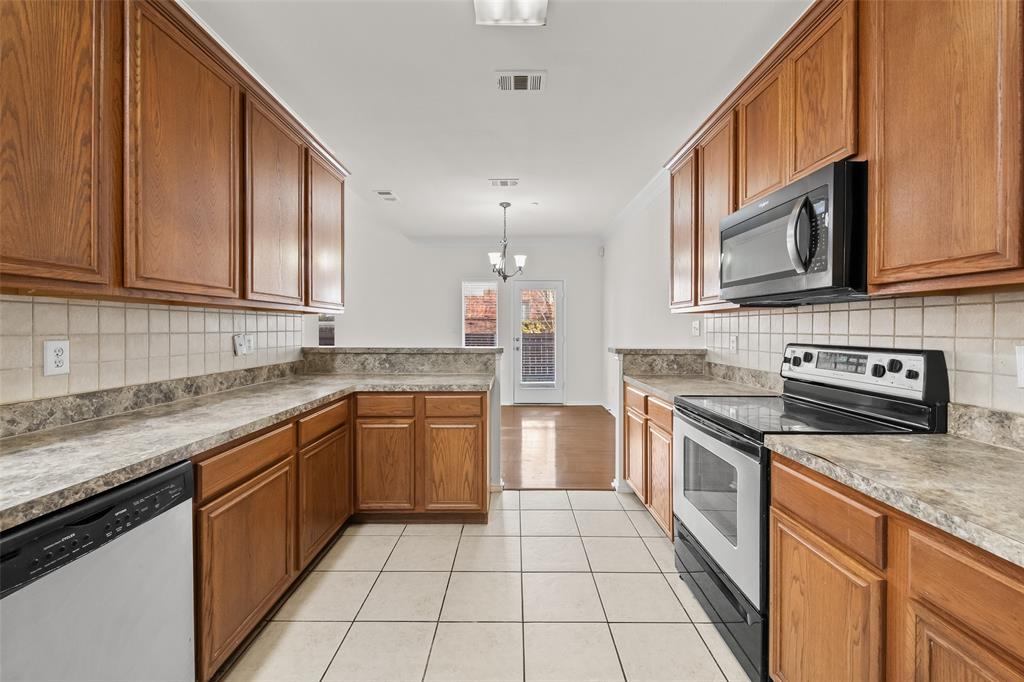 8524 Heather Ridge Drive Plano, TX 75024 - Photo 10 of 27 a kitchen with stainless steel appliances granite countertop a stove a sink and a microwave