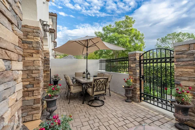 a view of a patio with chairs and potted plants