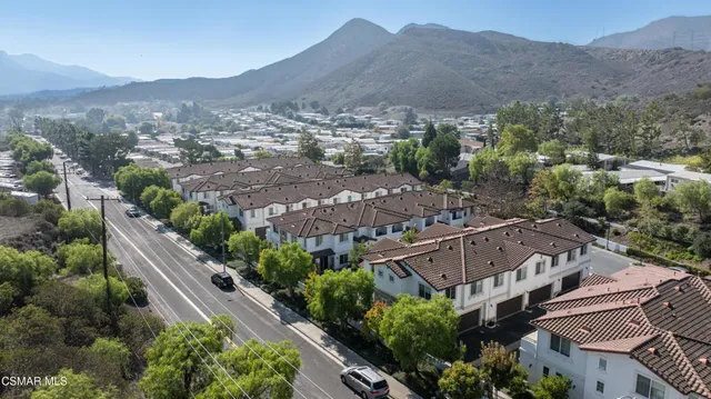 an aerial view of houses with a street and a mountain