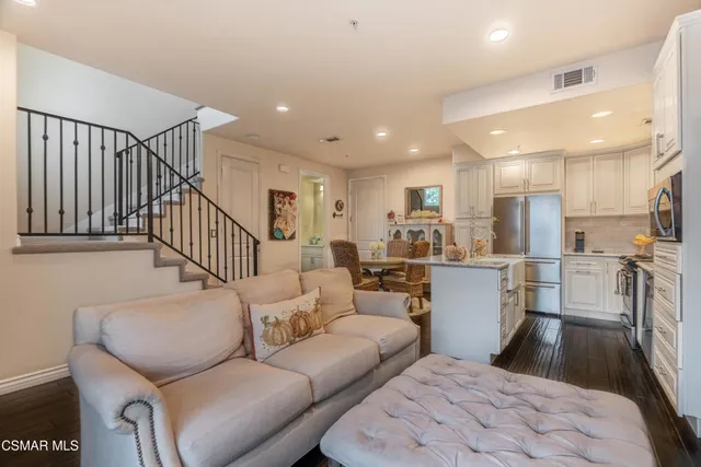 a living room with furniture a wooden floor and a chandelier