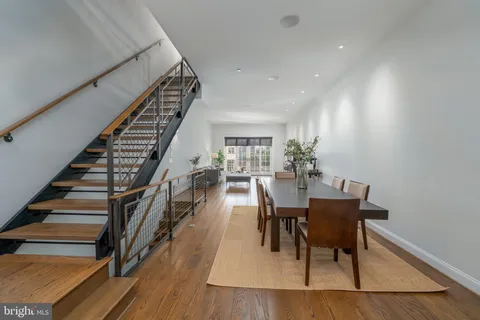 a dining room with furniture entryway and wooden floor