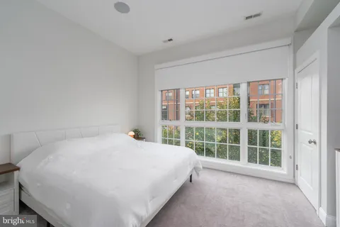 a large white bed sitting in a room next to a window