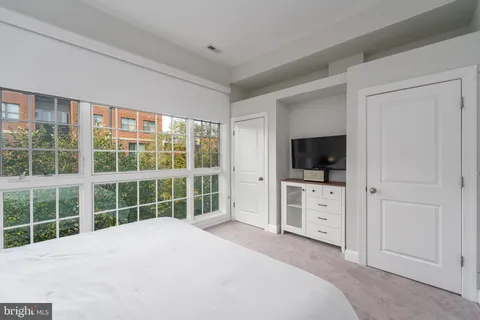 a view of a bedroom with window and flat screen tv