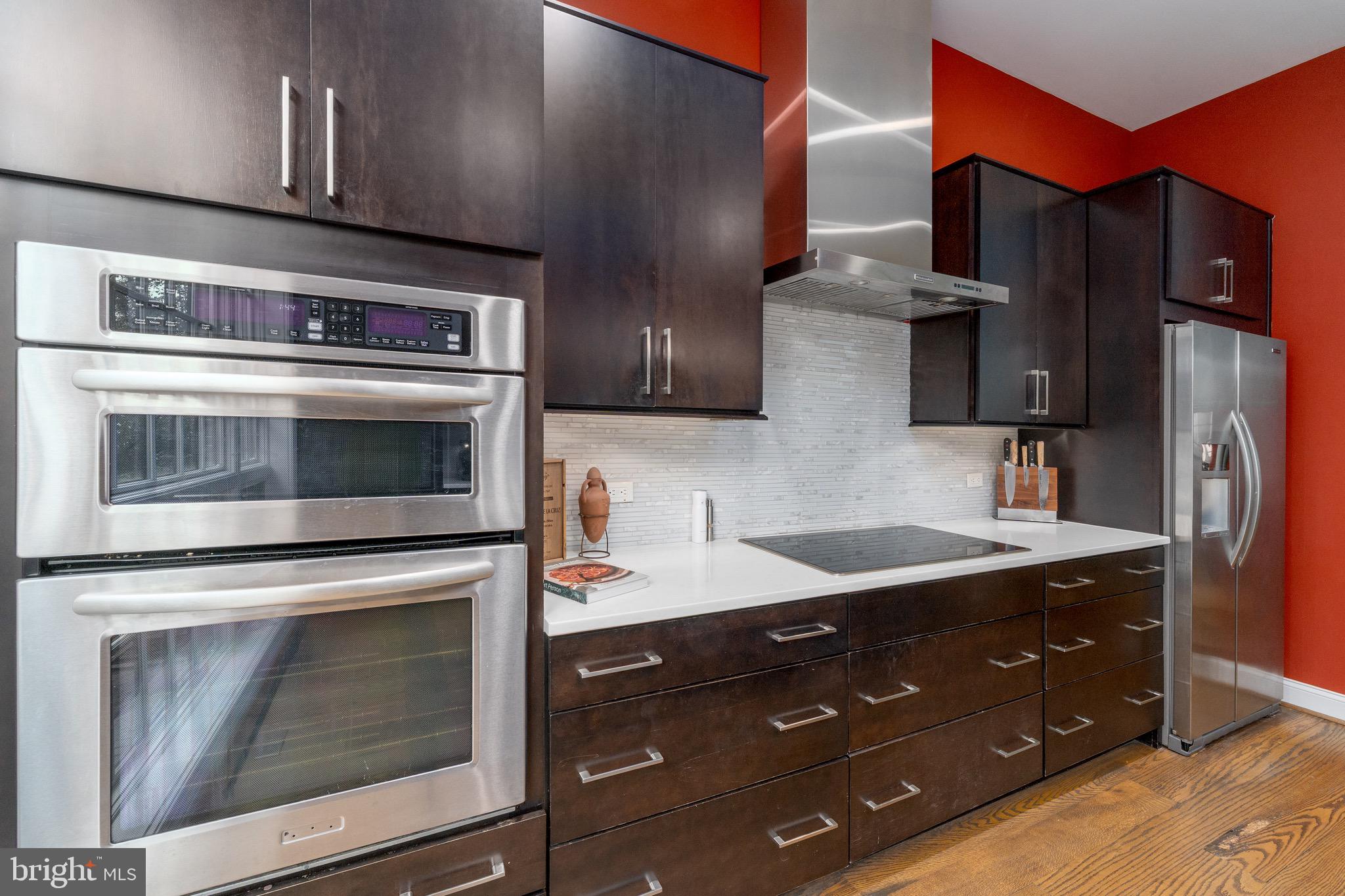 1735 Aliceanna Street Baltimore, MD 21231 - Photo 6 of 48 a kitchen with stainless steel appliances wooden cabinets and a stove top oven