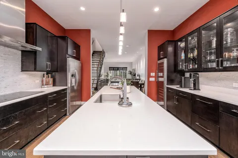 a large kitchen with stainless steel appliances a large counter top oven and cabinets