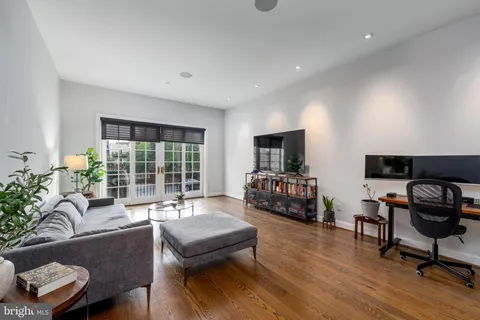 a living room with furniture and a flat screen tv with wooden floor