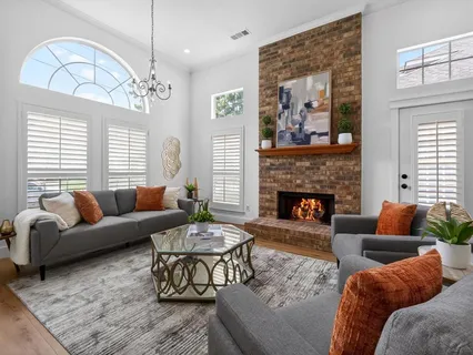 a living room with furniture a chandelier and a fireplace