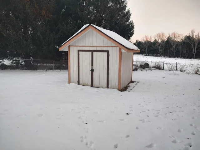 a front view of a house with a yard covered in snow
