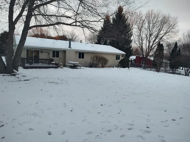 a view of a dry yard with trees in the background