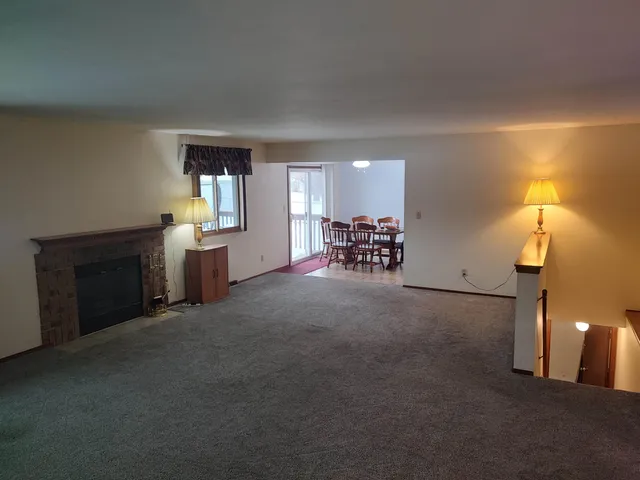 an empty room with windows cabinet and fireplace