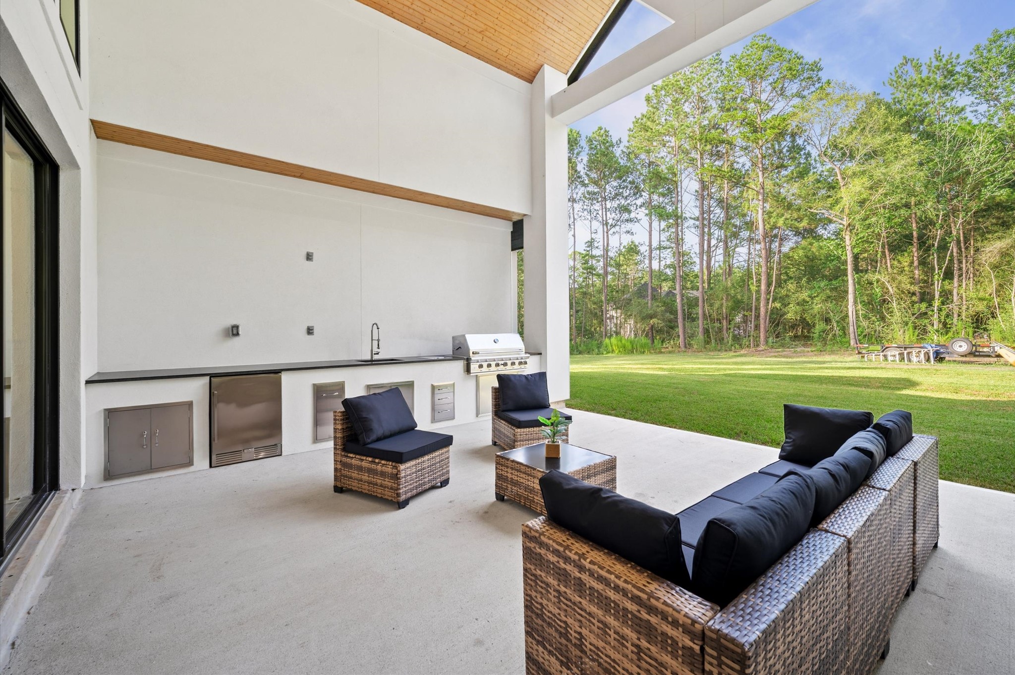 437 Sundog Road Huntsville, TX 77340 - Photo 48 of 50 Covered outdoor living area featuring vaulted wood ceiling accents and fully equipped outdoor kitchen.