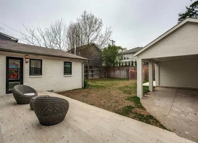 a backyard of a house with barbeque oven and outdoor seating
