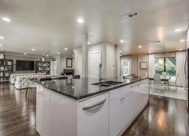 a kitchen with stainless steel appliances granite countertop a sink stove and wooden floor
