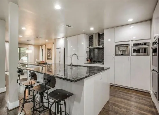 a kitchen with stainless steel appliances kitchen island granite countertop a sink and cabinets