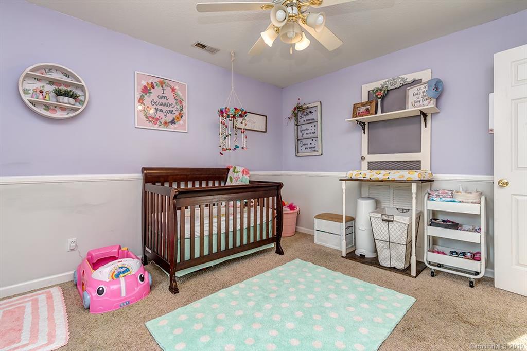 3115 Trinity Church Road Monroe, NC 28112 - Photo 22 of 27 a bedroom with a baby bed a dresser and chair
