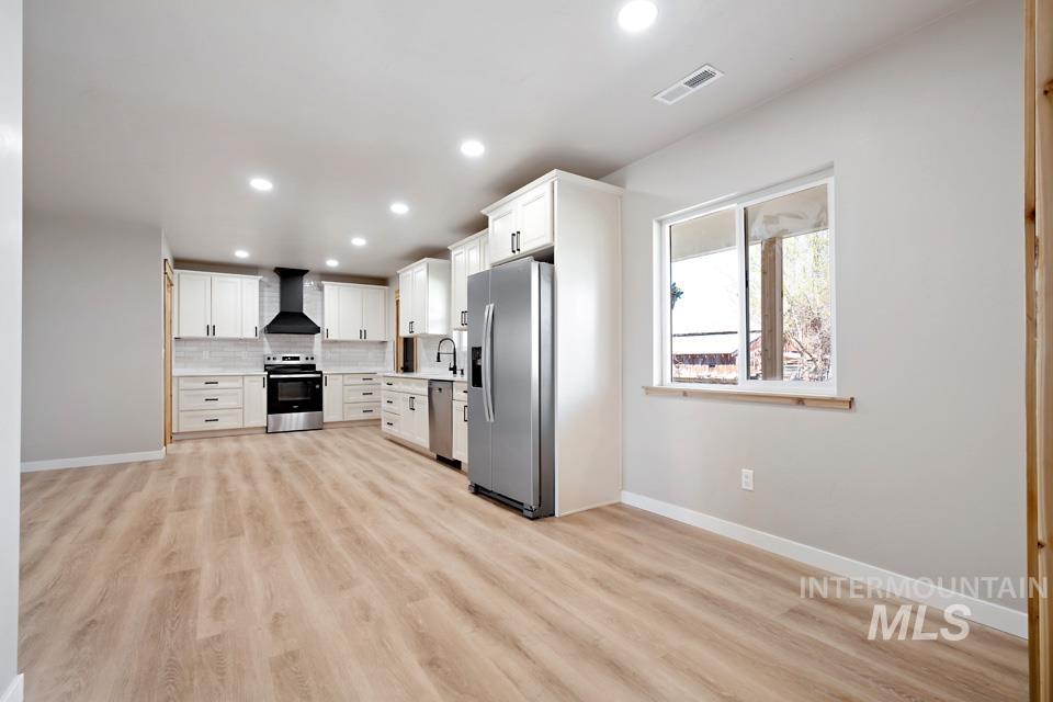 535 Day Road Weiser, ID 83672 - Photo 13 of 44 Kitchen with stainless steel appliances, white cabinets, tasteful backsplash, light wood-type flooring, and recessed lighting