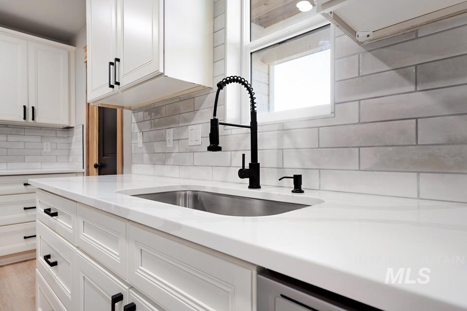 535 Day Road Weiser, ID 83672 - Photo 15 of 44 Kitchen featuring white cabinets, light stone countertops, and tasteful backsplash