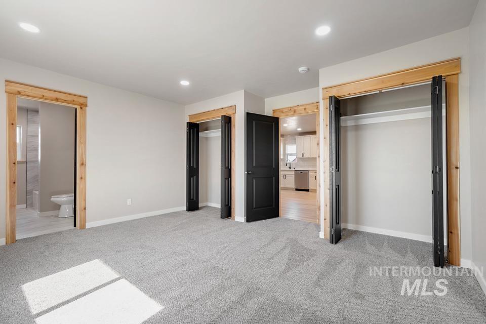 535 Day Road Weiser, ID 83672 - Photo 22 of 44 Unfurnished bedroom featuring two closets, light colored carpet, ensuite bath, and recessed lighting