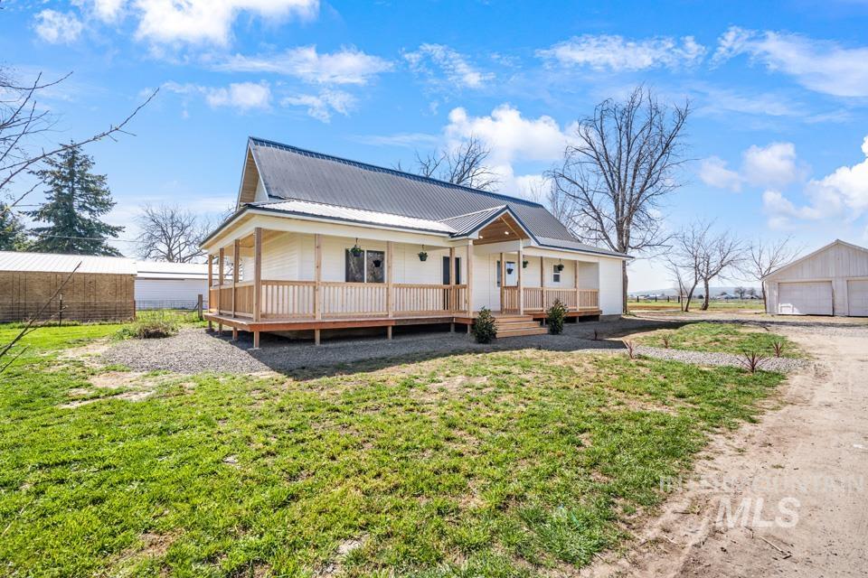 535 Day Road Weiser, ID 83672 - Photo 32 of 44 View of front facade with an outbuilding, a porch, a front lawn, a garage, and a metal roof