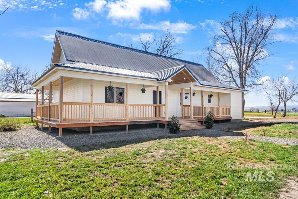 535 Day Road Weiser, ID 83672 - Photo 33 of 44 Farmhouse-style home featuring a large porch, a metal roof, and a front lawn