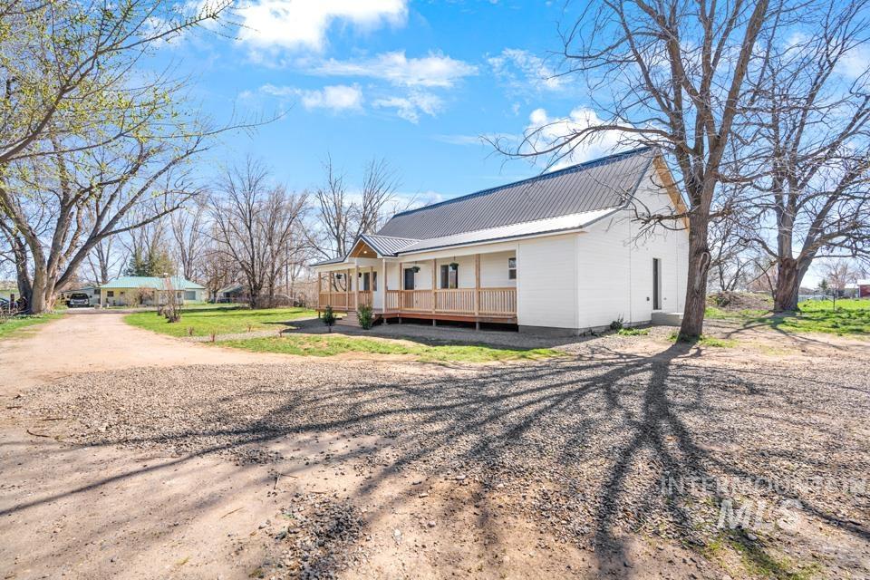 535 Day Road Weiser, ID 83672 - Photo 37 of 44 View of side of home featuring covered porch, dirt driveway, and a metal roof