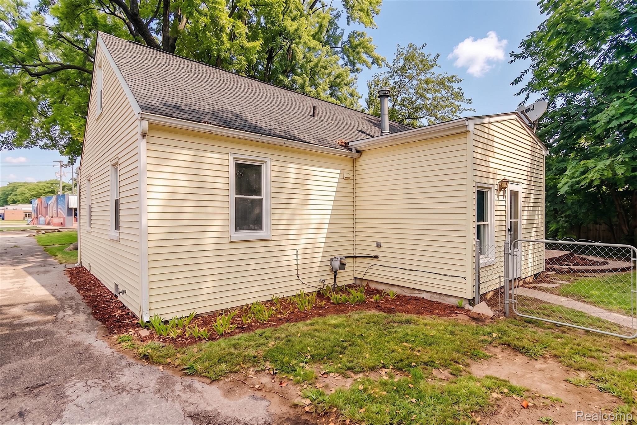 4644 South Rochester Road Royal Oak, MI 48073 - Photo 15 of 19 Yellow siding exterior with white window trim and a dark shingle roof