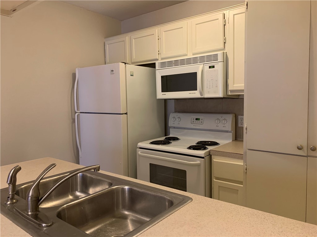 a kitchen with a stove sink and refrigerator