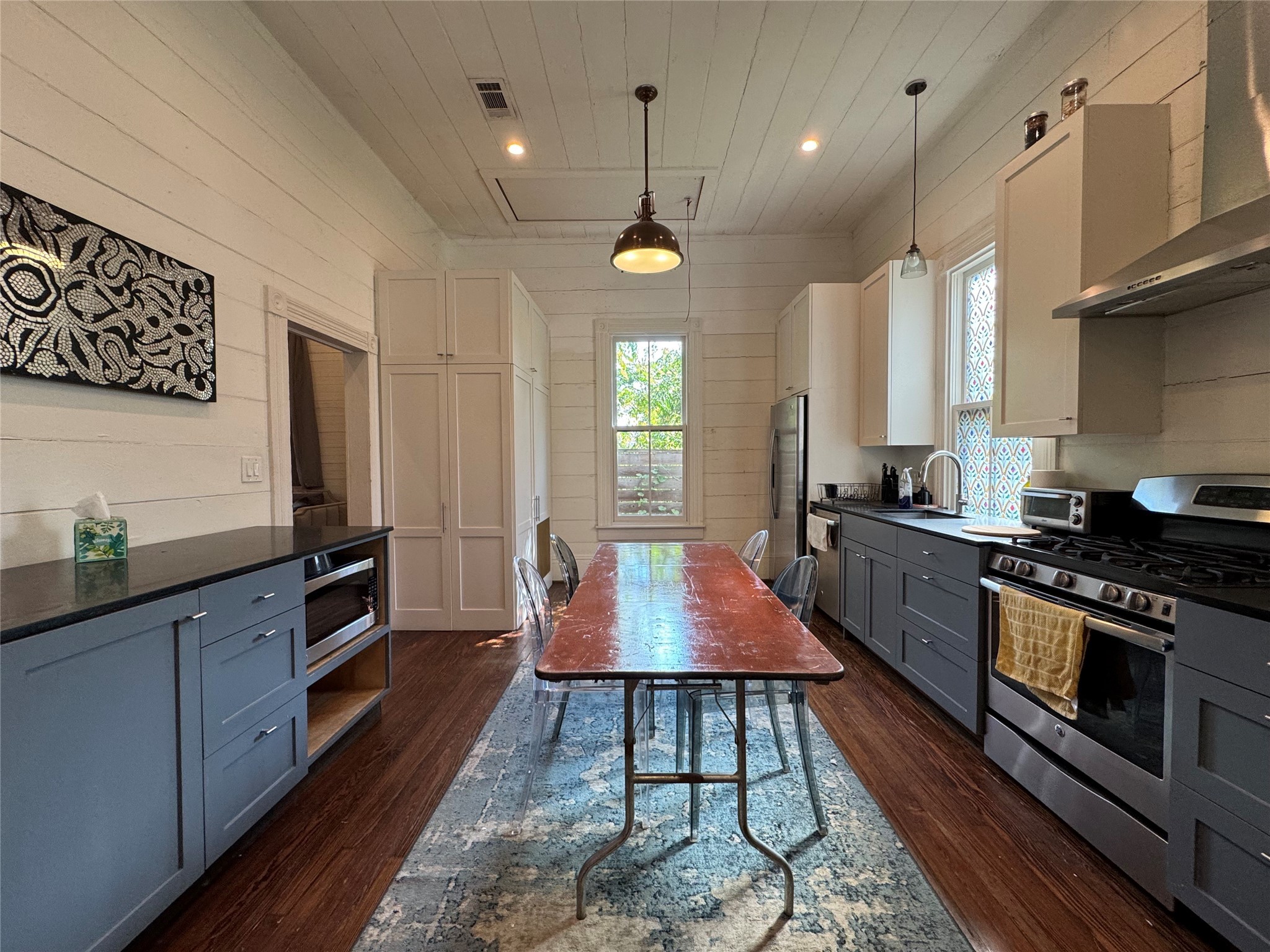 3408 Garrow Street, Unit A Houston, TX 77003 - Photo 18 of 30 a kitchen with stainless steel appliances granite countertop a stove a sink dishwasher a microwave oven and a dining table with wooden floor