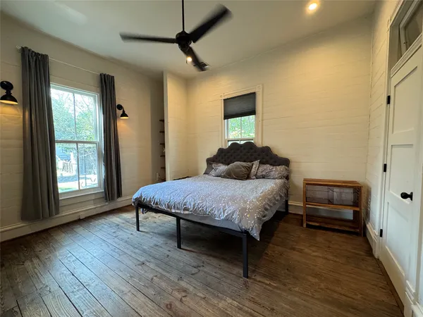 a bedroom with a bed and wooden floor