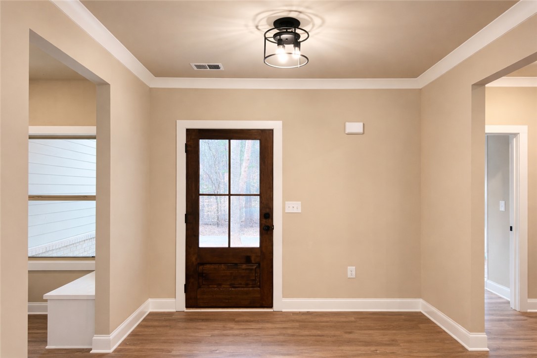 111 Birch Court Westminster, SC 29693 - Photo 2 of 27 This inviting entrance features a glass-paned door, crown molding, and rich wood flooring.