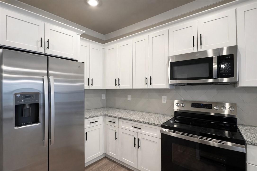 111 Birch Court Westminster, SC 29693 - Photo 9 of 27 This modern kitchen features crisp white cabinetry and granite countertops, perfect for culinary endeavors.