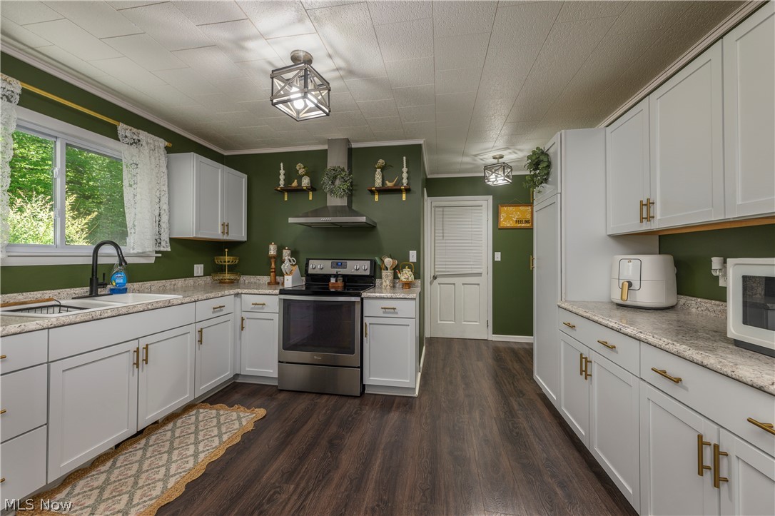 6105 Wolf Run Road Southeast Dennison, OH 44621 - Photo 21 of 35 Kitchen featuring white cabinetry, dark wood-finish flooring, a stainless steel range, and a matching stainless steel range hood