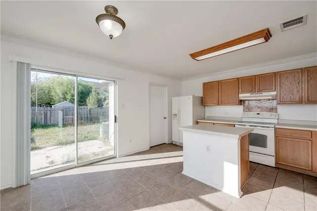 a kitchen with stainless steel appliances granite countertop a stove a sink and a refrigerator