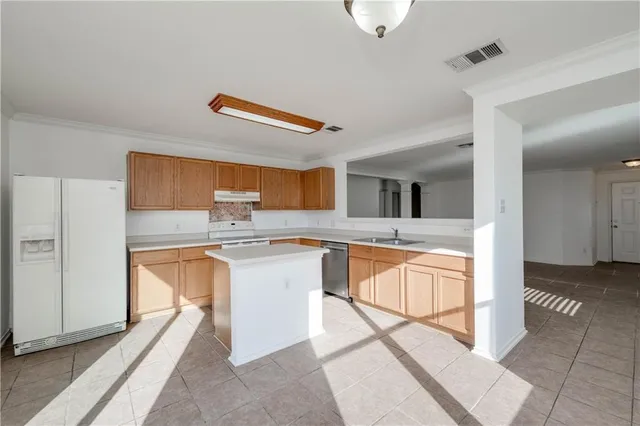 a kitchen with stainless steel appliances granite countertop a refrigerator and a stove top oven