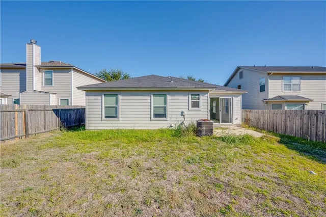 a backyard of a house with barbeque oven table and chairs