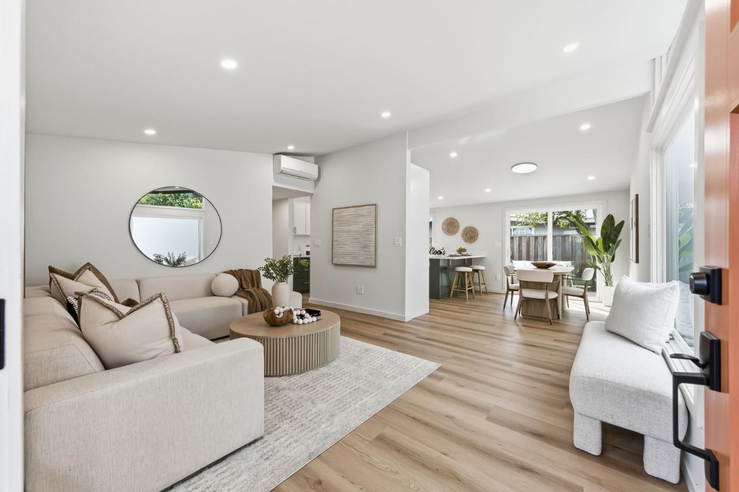 a living room with furniture a mirror and a table