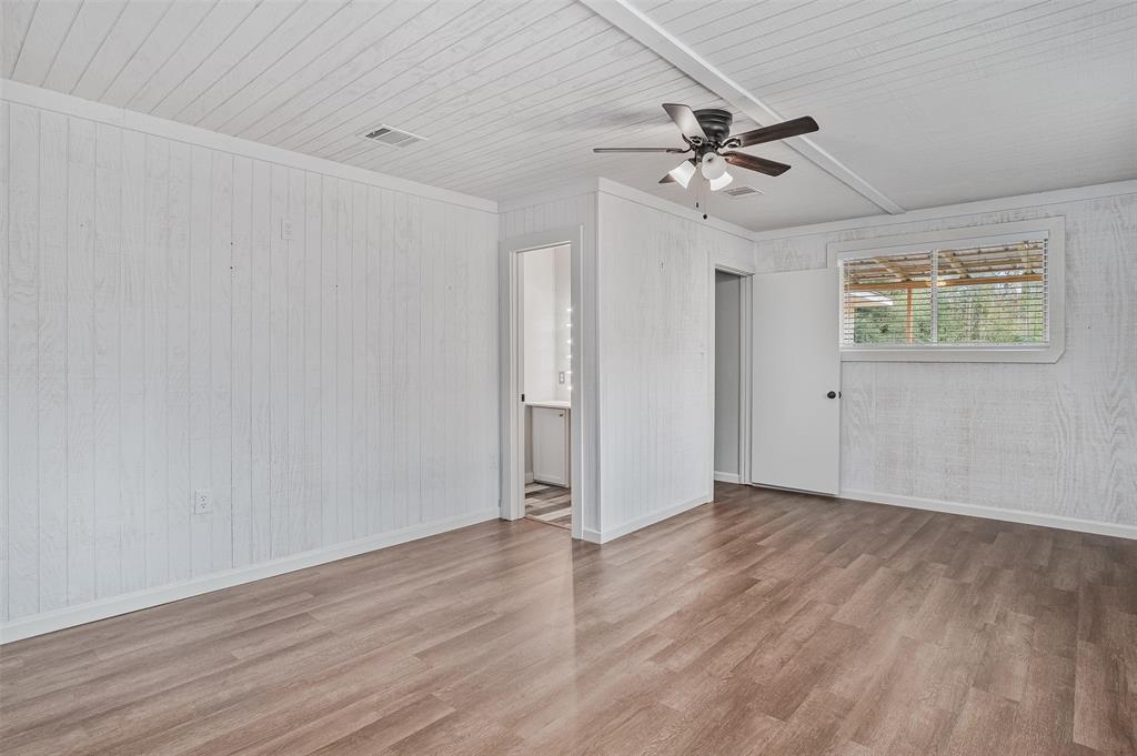 4340 Pruett Road Shreveport, LA 71107 - Photo 14 of 24 an empty room with wooden floor ceiling fan and windows