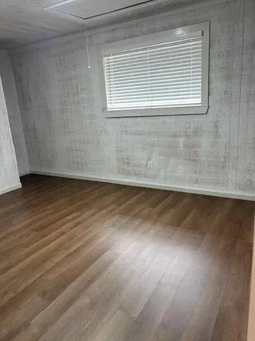 a view of a room with wooden floor and a window