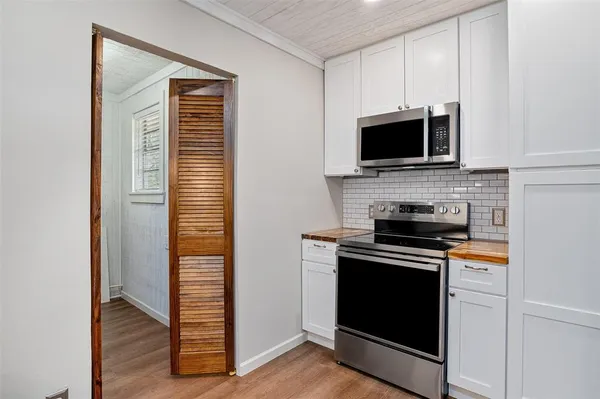 a large kitchen with granite countertop a large counter top space and stainless steel appliances