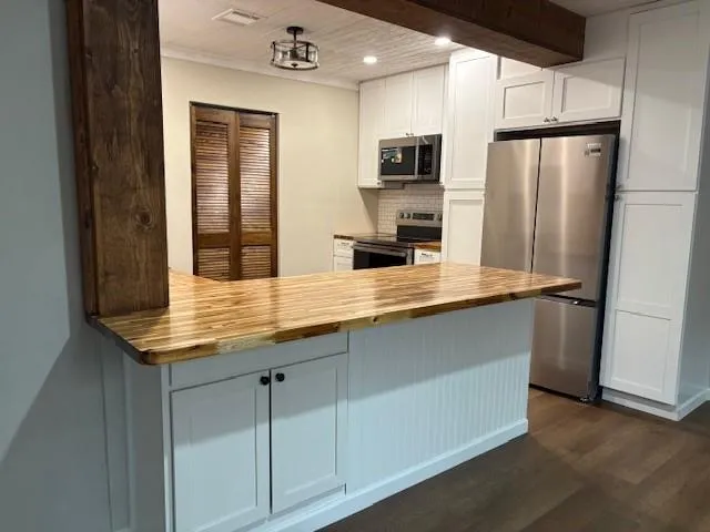 a kitchen with stainless steel appliances a sink stove refrigerator and cabinets