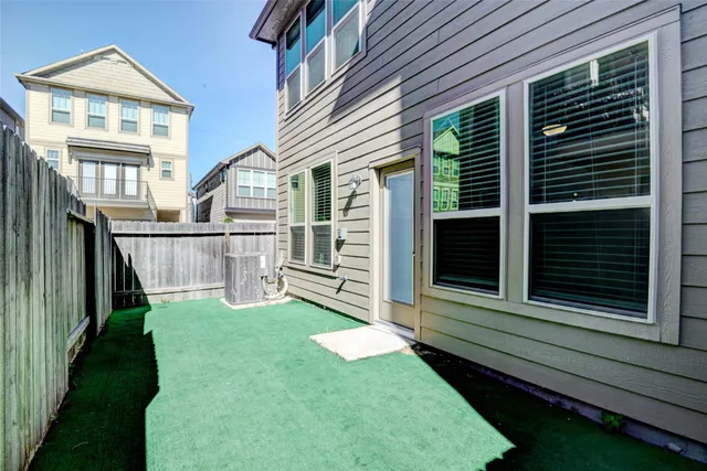 a view of a house with backyard and wooden fence