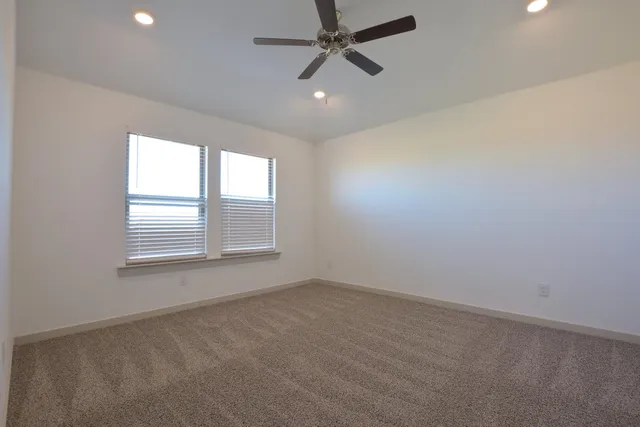 an empty room with a window and a fan