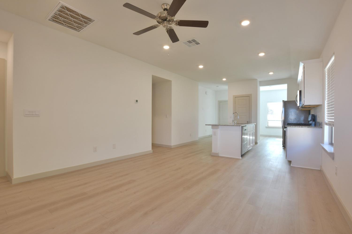 7438 8th Street Lubbock, TX 79416 - Photo 7 of 18 a view of a kitchen with a sink and a refrigerator