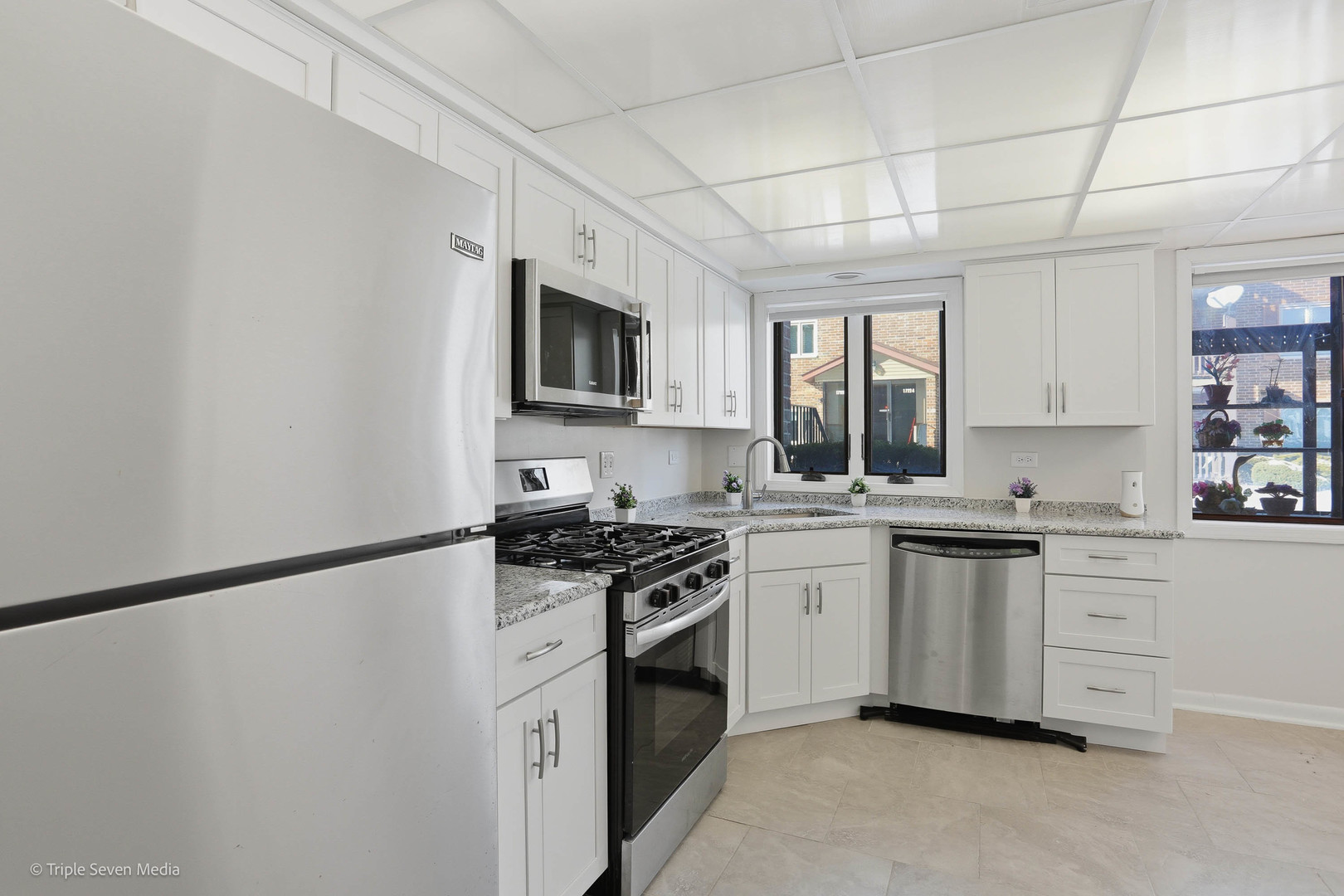 17236 Ridgeland Avenue, Unit 412 Tinley Park, IL 60477 - Photo 13 of 23 a kitchen with granite countertop white cabinets sink and stainless steel appliances