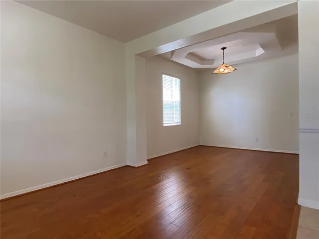 an empty room with wooden floor and window