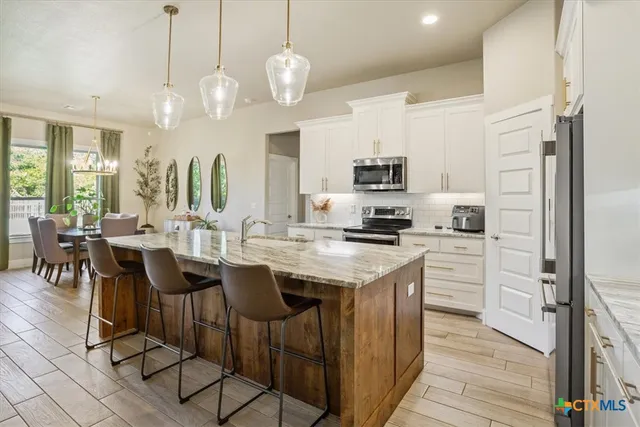 a kitchen with stainless steel appliances kitchen island granite countertop a sink and cabinets