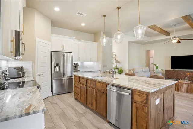 a kitchen with a refrigerator a sink and a wooden floor