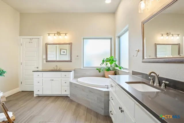 a bathroom with a granite countertop sink mirror and bathtub